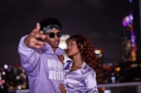 a man and woman posing for a picture on a rooftop