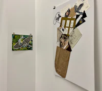 a room with several pieces of art hanging on the wall