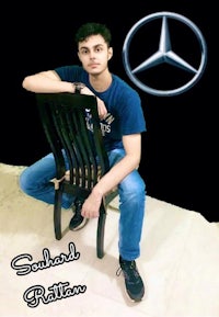 a man sitting on a chair with a mercedes benz logo