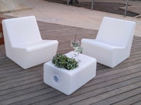 two white lounge chairs on a wooden deck