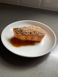 a piece of salmon with sesame seeds on a plate