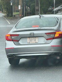 a silver honda accord is driving down the street