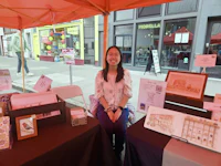 a woman sits at a table with a table full of items