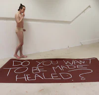 a man in a bikini standing next to a sign that says do you want to be made healed?