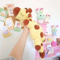 a person is holding a stuffed giraffe