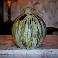 a vase sitting on top of a marble table