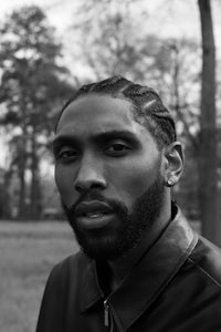 a black and white photo of a man in a leather jacket