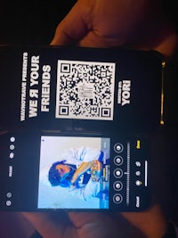 a person holding a phone with a qr code on it