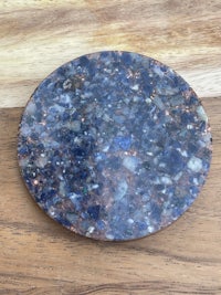 a blue stone coaster on a wooden table