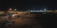 a group of airplanes parked on the tarmac at night