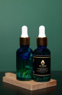 two bottles of essential oil on a wooden board