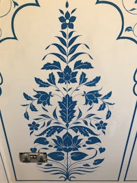a blue and white floral design on a wall