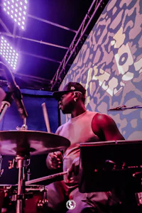 a man playing drums in front of a stage