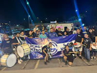 a group of people posing with a banner and drums