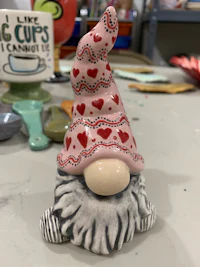a ceramic gnome is sitting on a table