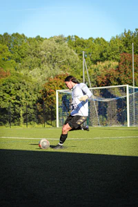 a man kicking a soccer ball on a soccer field