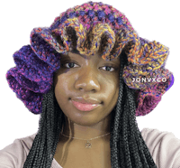 a black woman wearing a colorful crocheted hat