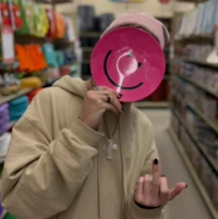 a person holding a pink smiley face in a store