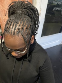 a woman with dreadlocks sitting in a salon