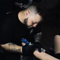 a man is getting a tattoo on his arm