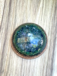 a green and blue apatite stone on a wooden surface