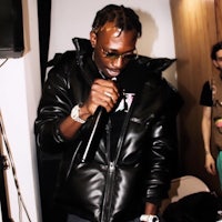 a man in a black jacket is holding a microphone