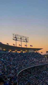 a baseball stadium at dusk with people watching a game
