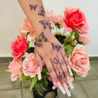 a woman's hand with butterflies tattooed on it
