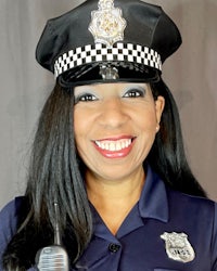 a woman in a police uniform smiling and holding a microphone