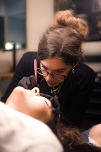 a woman getting her eyebrows pierced