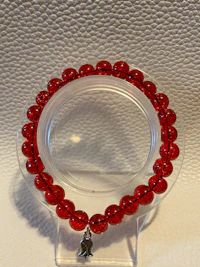 a red glass bead bracelet on a clear surface