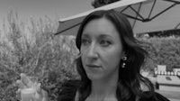 a woman is holding a glass of wine