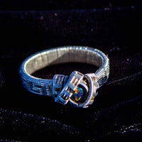 a silver ring on a black cloth