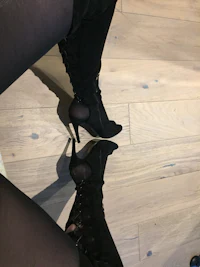 a woman's legs in black thigh high boots