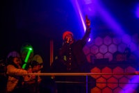 a man on stage with a microphone in front of a crowd of people