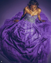 a woman in a purple dress posing on a purple background