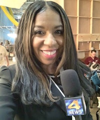 a woman holding a microphone and smiling