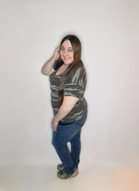 a woman wearing jeans and a camouflage shirt