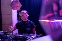 a dj is playing a dj set in front of a crowd