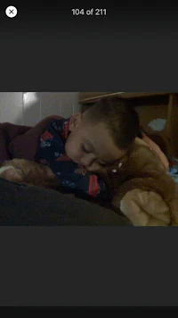 a child is sleeping on a bed with a teddy bear