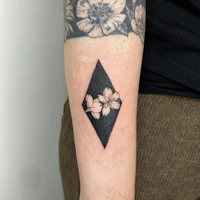 a black and white diamond tattoo with flowers on it