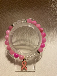 a pink bracelet with a pink ribbon on it