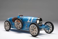a model of a blue racing car on a white background