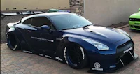 a blue nissan gtr parked in front of a house