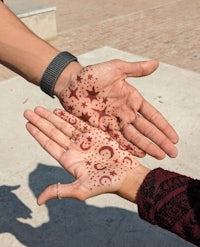 two hands with henna tattoos on them