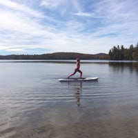 a woman is standing on a surfboard in a body of water