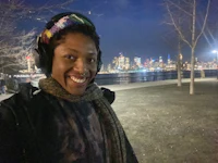 a woman is taking a selfie in front of a city skyline