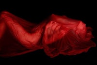 a red clothed woman laying on a black background