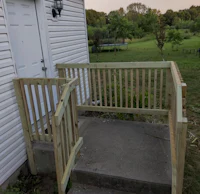 a wooden porch with a railing and a door