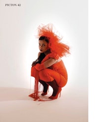 a woman in an orange costume crouching down